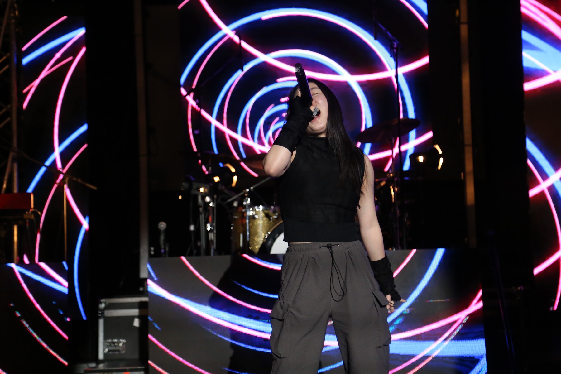 Vocalist performing in front of neon lights